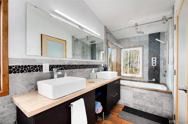 a bathroom with a sink a large mirror and a bathtub