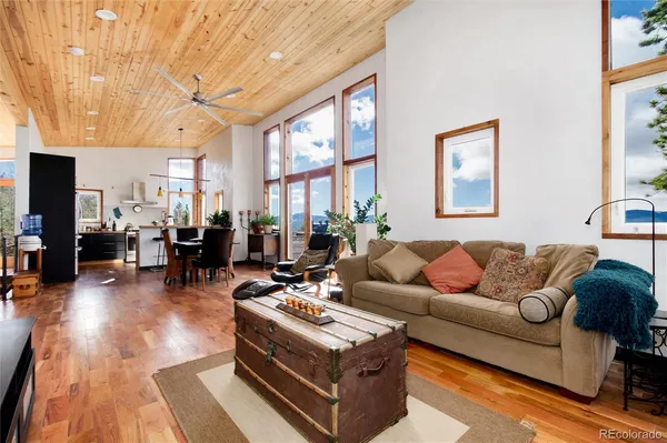 a living room with furniture kitchen view and a large window