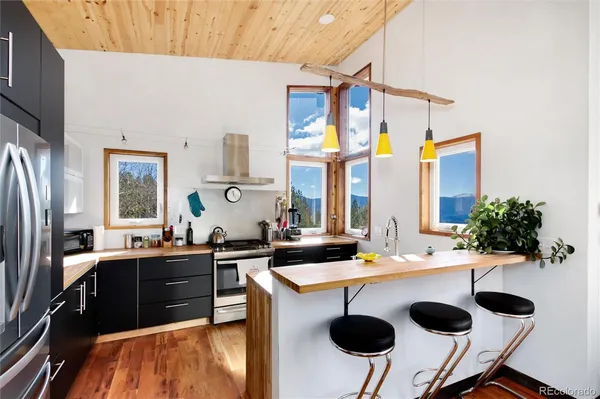 a kitchen with stainless steel appliances granite countertop a sink and a refrigerator