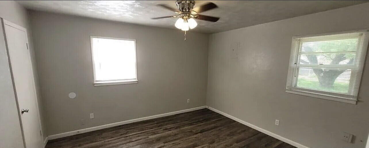 4427 31st Street, Unit A Lubbock, TX 79410 - Photo 5 of 9 an empty room with windows and fan