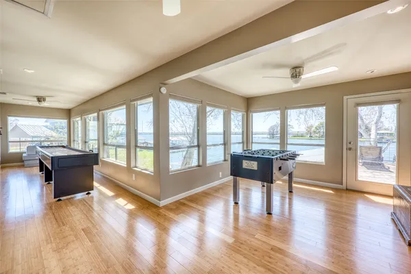 a living room with furniture a large window and wooden floor