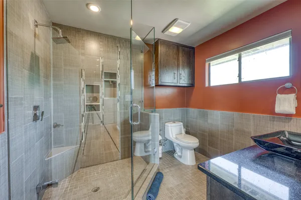 a bathroom with a sink a toilet and shower