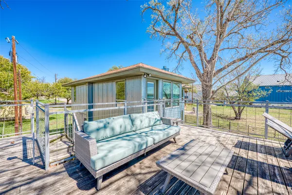 a view of a roof deck with couches and wooden fence