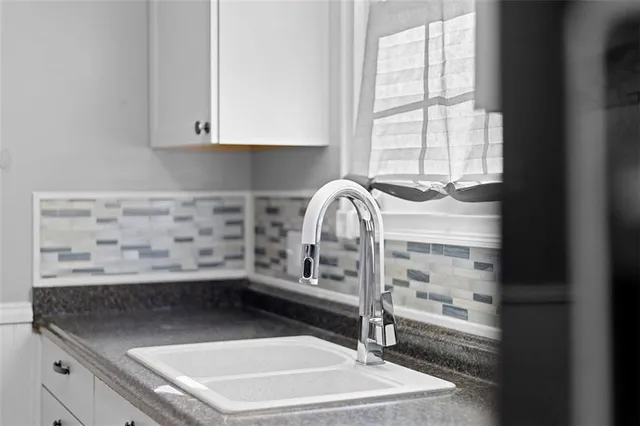 a kitchen with a sink a stove and cabinets