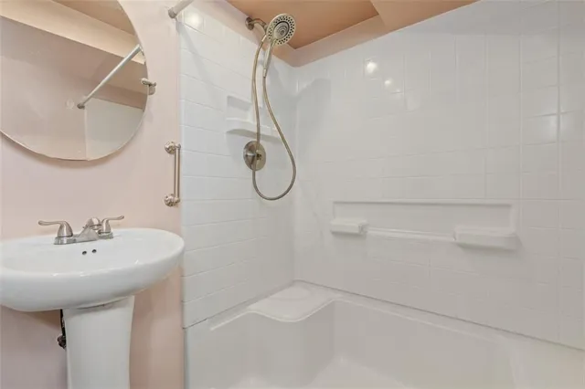 a bathroom with a sink a mirror and shower