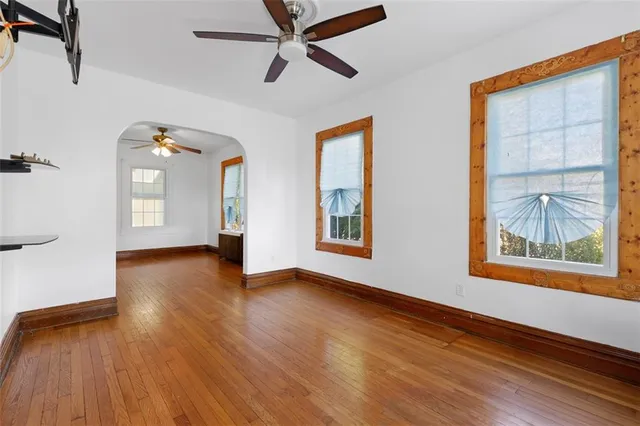 a view of an empty room with a window and wooden floor