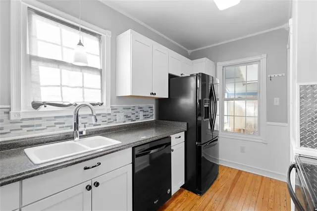 a kitchen with a sink a refrigerator and cabinets
