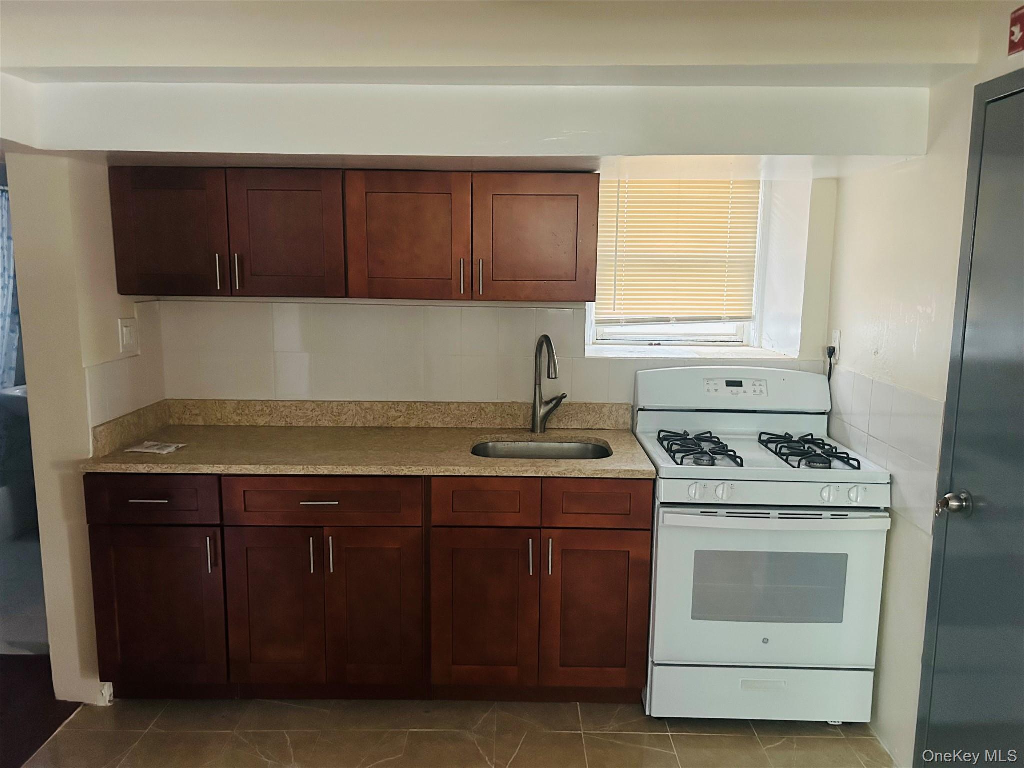 2910 Tenbroeck Avenue Bronx, NY 10469 - Photo 4 of 9 a kitchen with a stove sink and cabinets