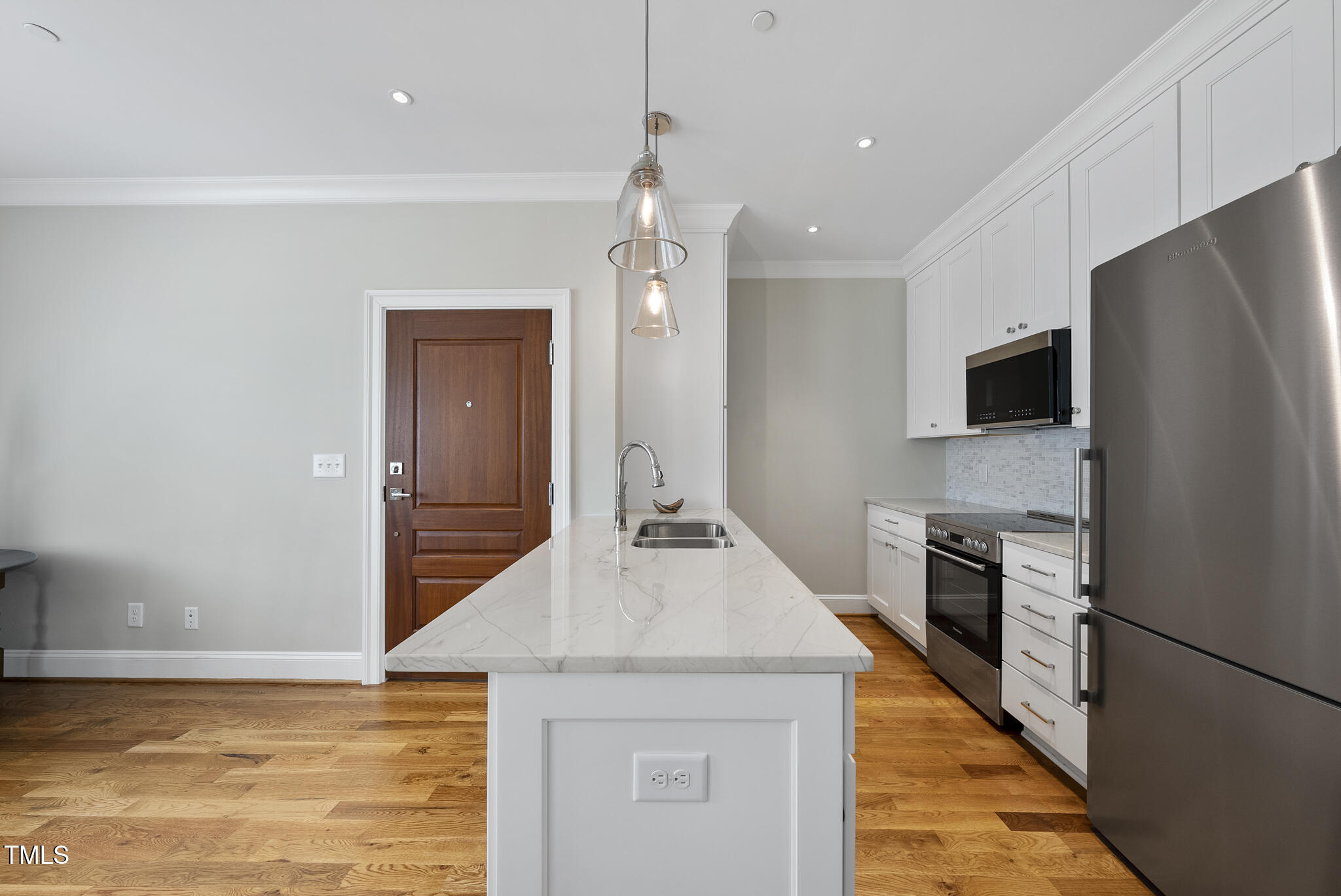 606 Daniels Street, Unit B Raleigh, NC 27605 - Photo 15 of 27 a kitchen with kitchen island a counter top space appliances and cabinets