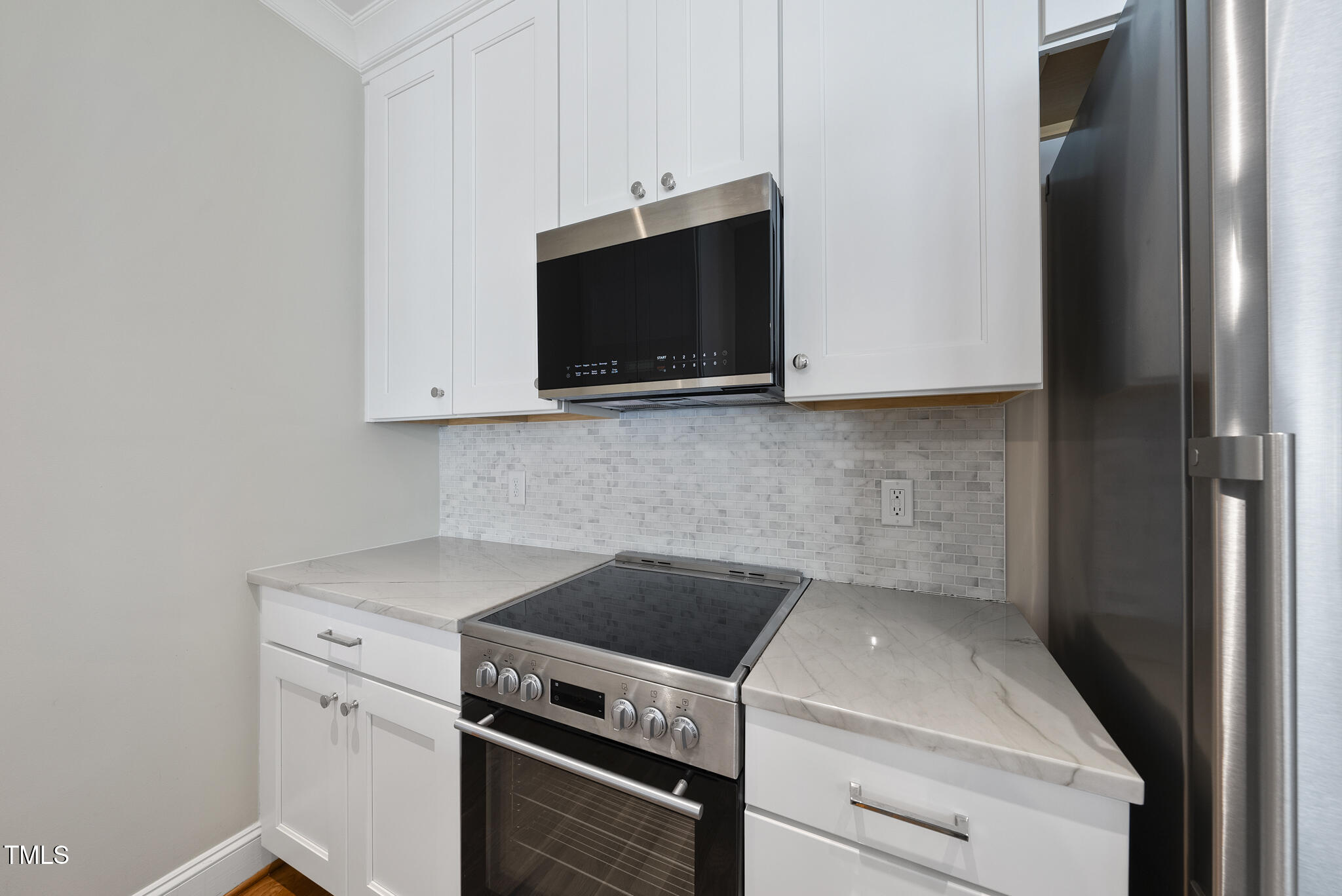 606 Daniels Street, Unit B Raleigh, NC 27605 - Photo 5 of 27 a kitchen with a stove and a microwave