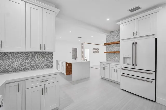 a kitchen with white cabinets and white appliances
