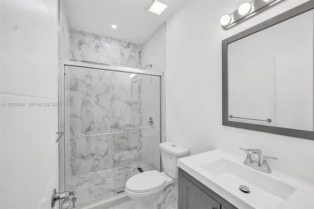 a bathroom with a sink mirror toilet and shower