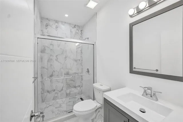 a bathroom with a sink mirror toilet and shower