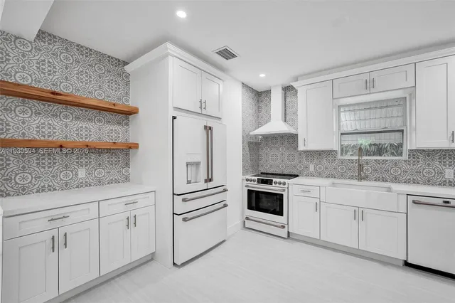 a kitchen with white cabinets and white appliances