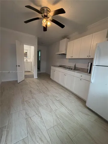a kitchen with a refrigerator sink stove and cabinets