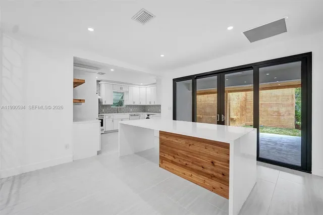 a large white kitchen with a large window