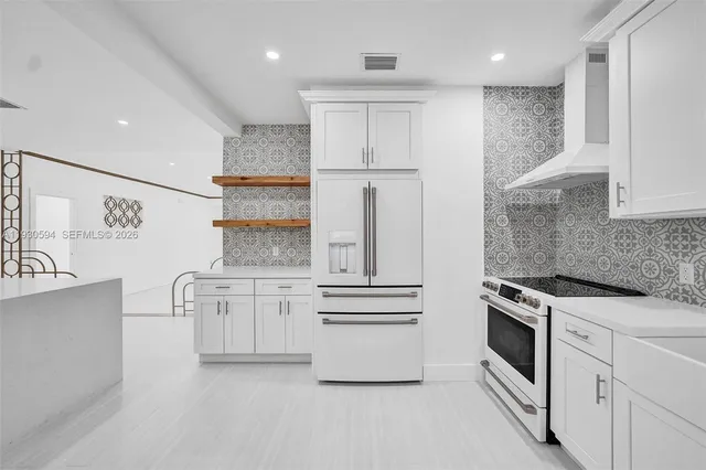 a kitchen with white cabinets and white appliances