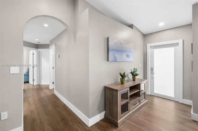 a backyard of a house with table and chairs and potted plants