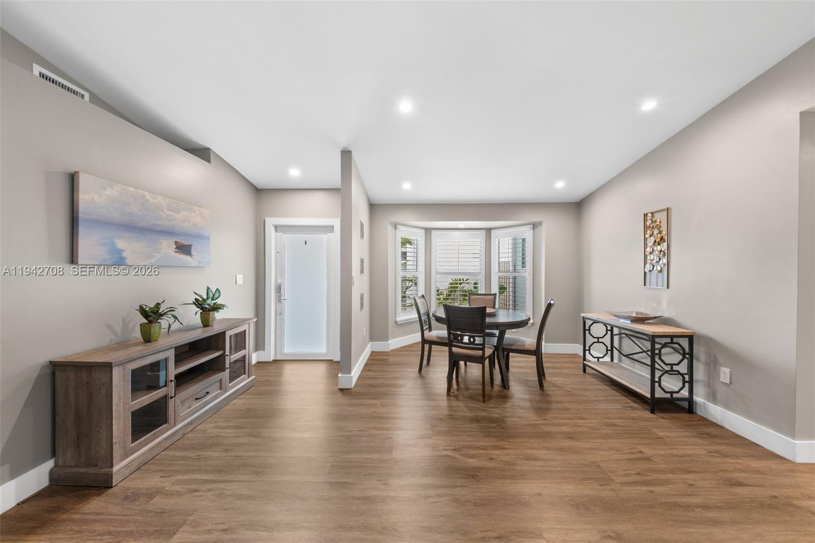 22239 Southwest 98th Place Cutler Bay, FL 33190 - Photo 48 of 67 a dining room with furniture wooden floor a rug and a painting