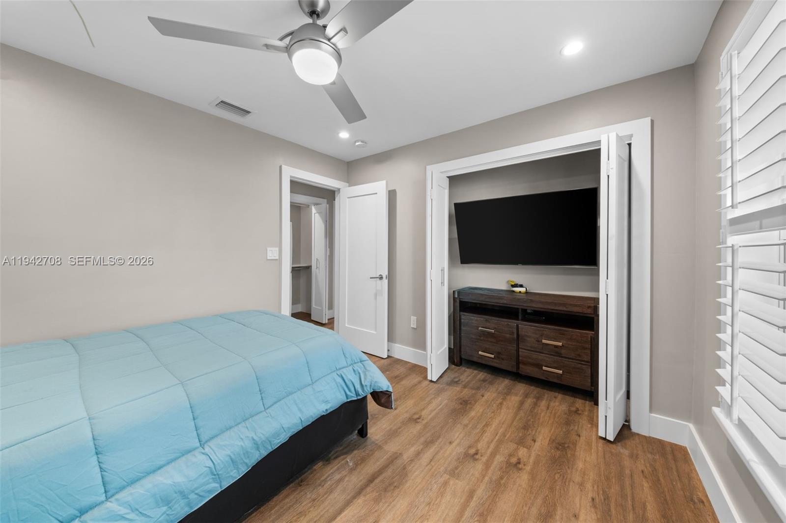 22239 Southwest 98th Place Cutler Bay, FL 33190 - Photo 55 of 67 a bedroom with a bed and a flat tv screen on dresser