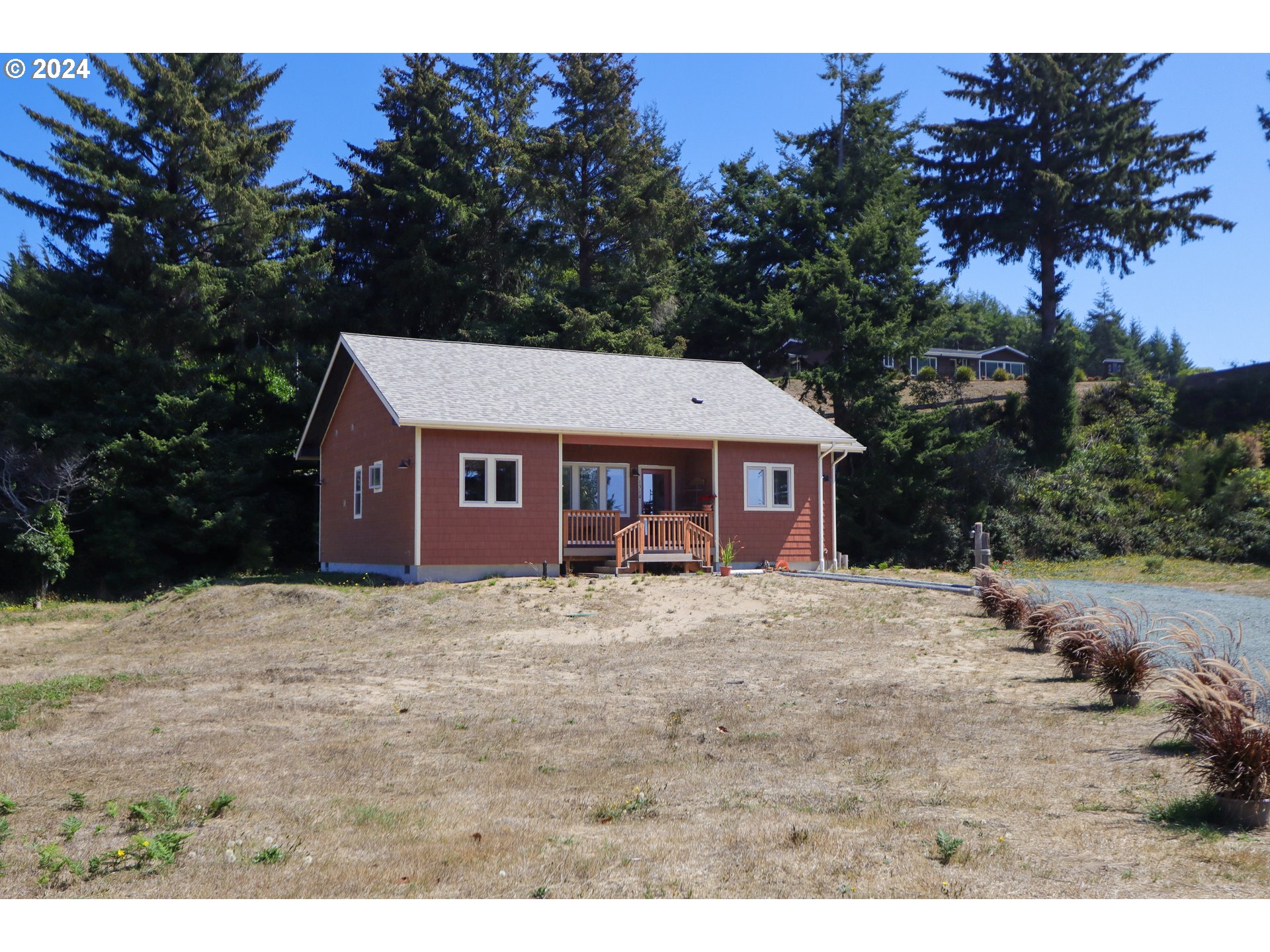1310 Riverside Drive Northeast Bandon, OR 97411 - Photo 29 of 42 a house with trees in the background