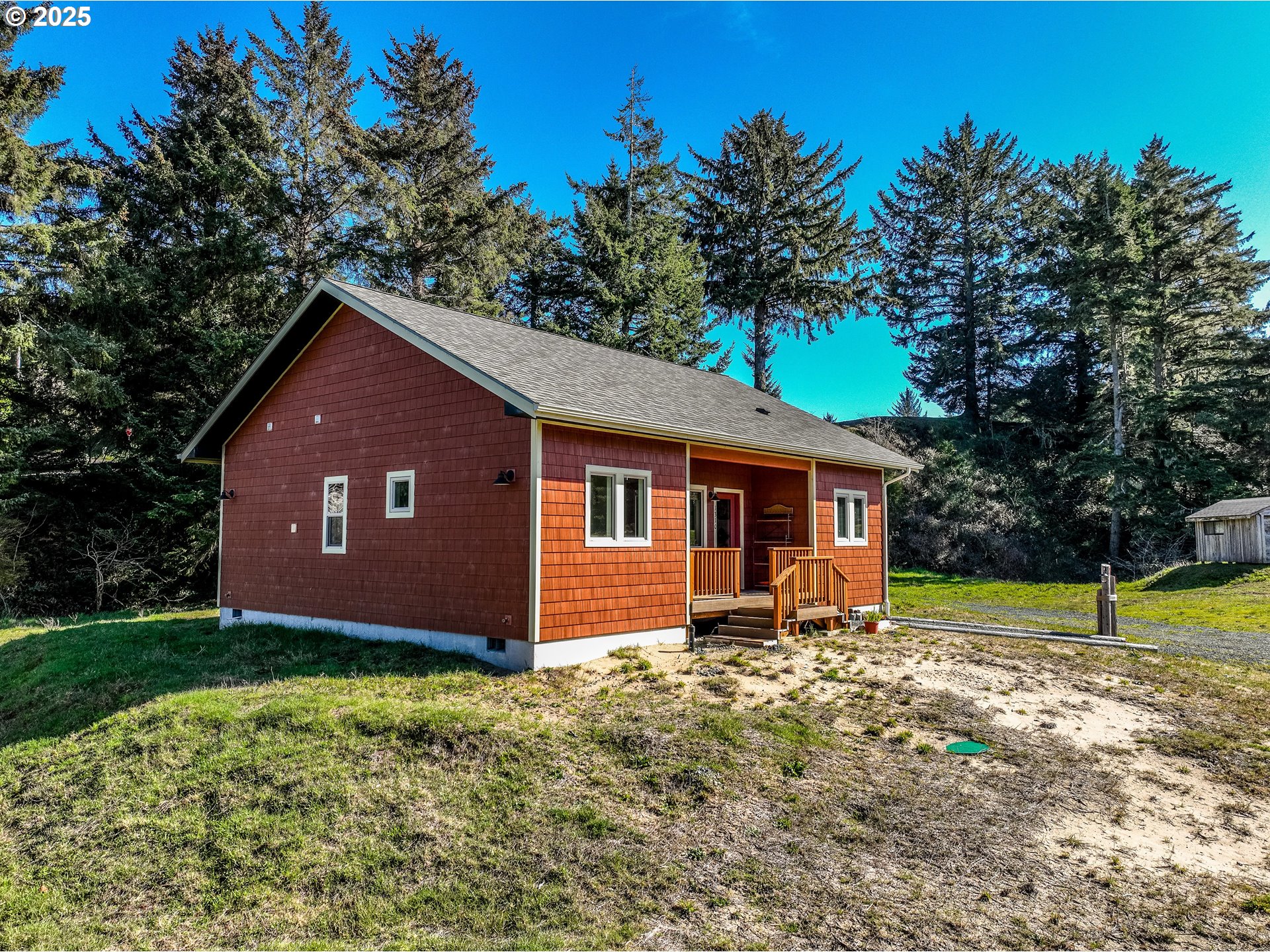 1310 Riverside Drive Northeast Bandon, OR 97411 - Photo 42 of 42 a backyard of a house with wooden fence and large trees