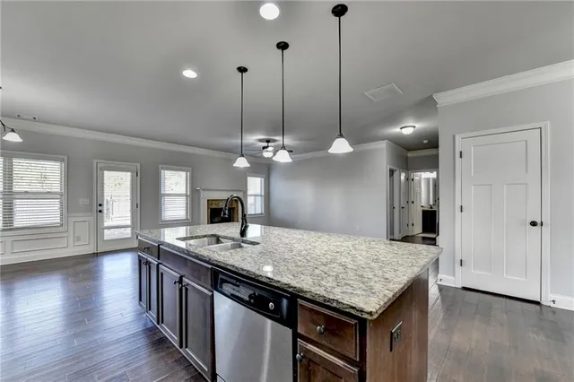 an empty room with windows fireplace and wooden floor