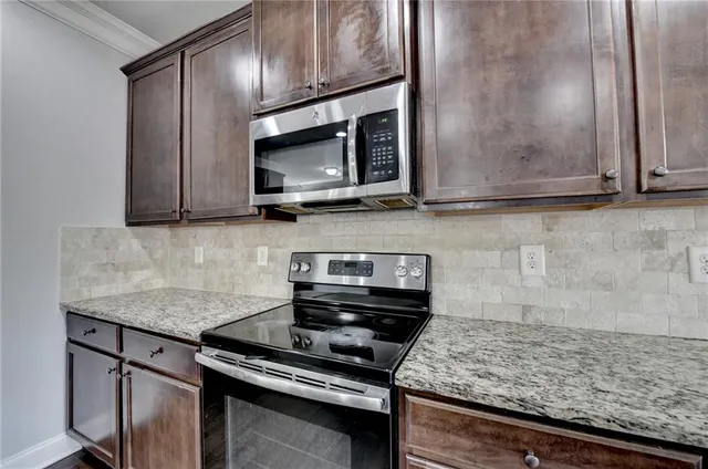 a view of an empty room with wooden floor and closet