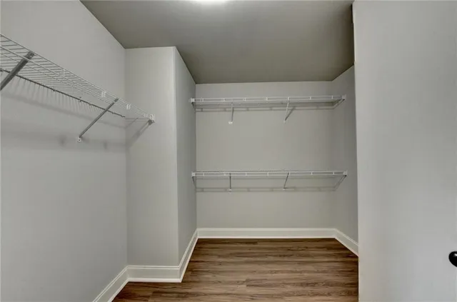 a room with a walk in closet and wooden floor