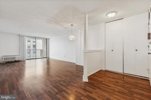 a view of empty room with wooden floor and window