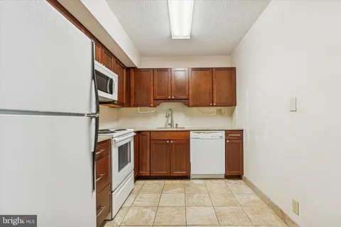 a kitchen with a sink a stove top oven and cabinets