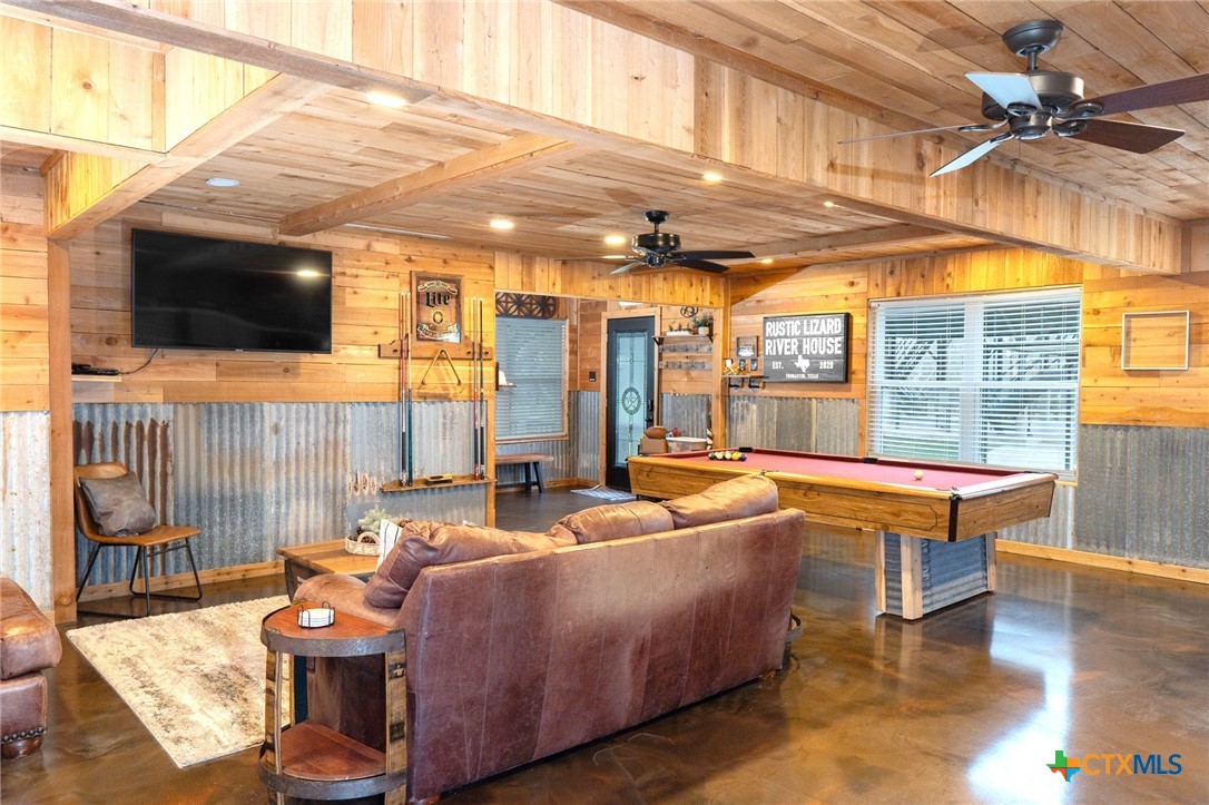 582 Cypress Valley Road Cuero, TX 77954 - Photo 16 of 36 a living room with patio furniture and a flat screen tv