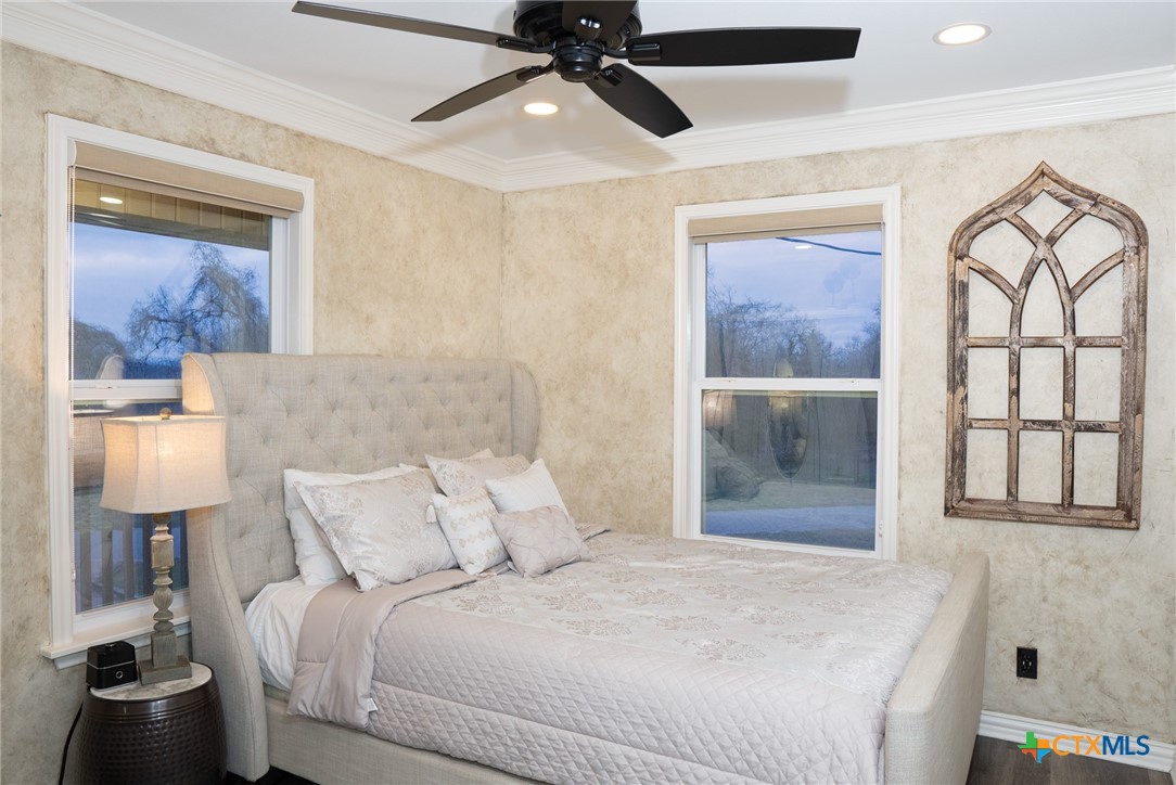 582 Cypress Valley Road Cuero, TX 77954 - Photo 27 of 36 a bedroom with a bed and a painting on the wall
