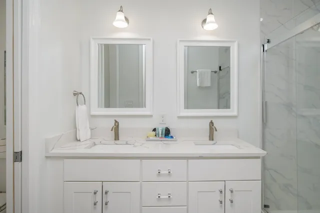 a bathroom with double sink and two mirror