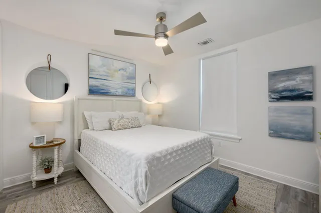 a bedroom with a bed and a lamp with the wooden floor