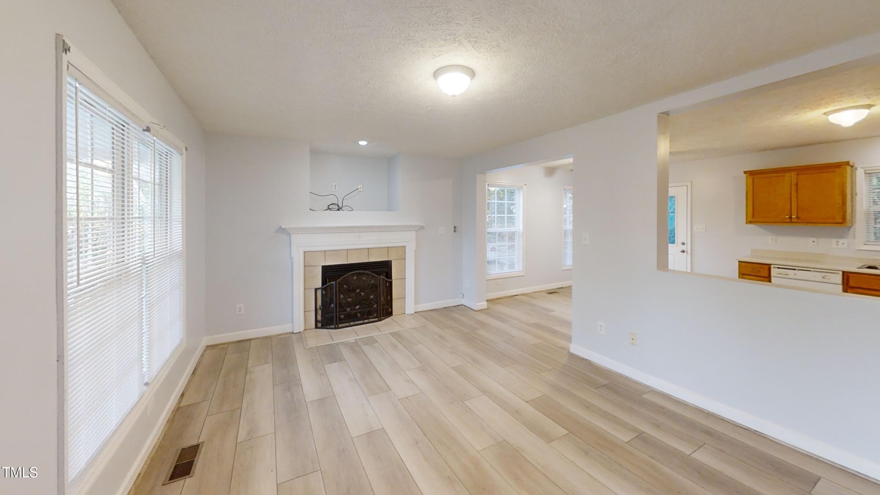 1420 East Lane Street Raleigh, NC 27610 - Photo 4 of 26 a view of an empty room with a fireplace and a window