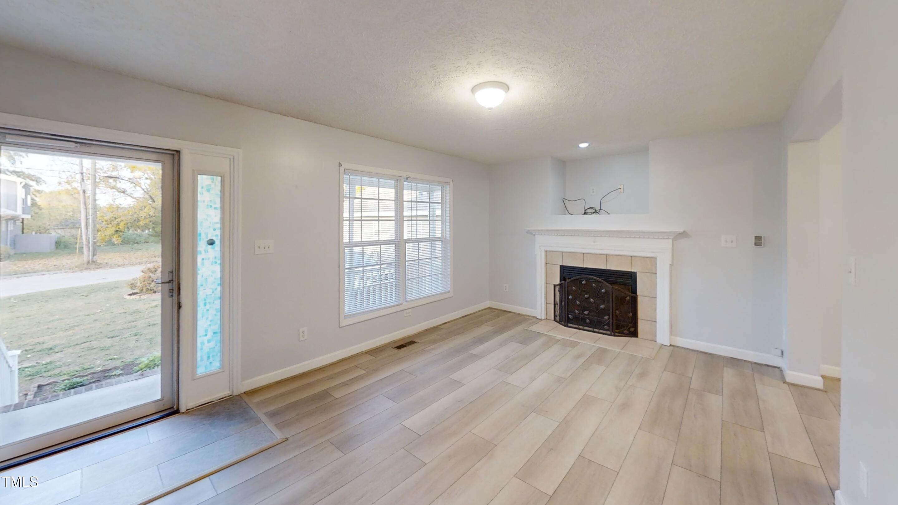 1420 East Lane Street Raleigh, NC 27610 - Photo 5 of 26 wooden floor fireplace and natural light in room