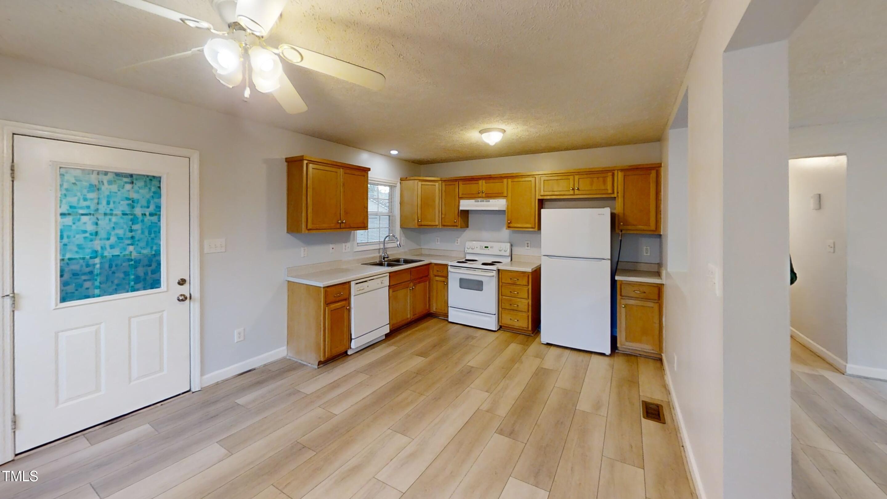 1420 East Lane Street Raleigh, NC 27610 - Photo 8 of 26 a kitchen with white cabinets and wooden floor