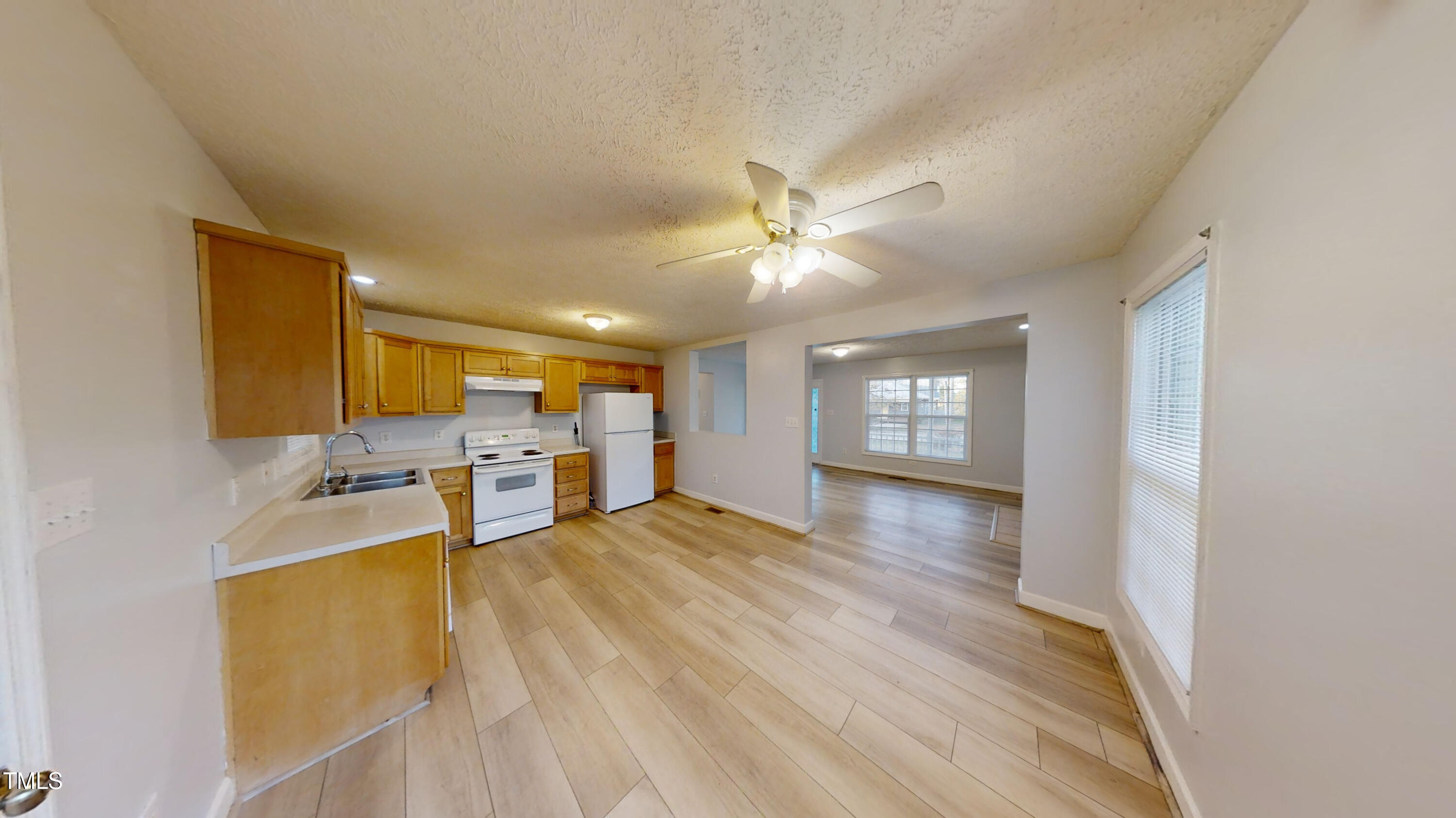 1420 East Lane Street Raleigh, NC 27610 - Photo 9 of 26 a view of a livingroom with furniture a ceiling fan and wooden floor