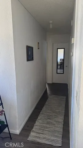 a view of a hallway with wooden floor and a bathroom