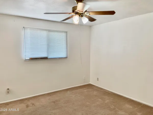 an empty room with a fan and a fan
