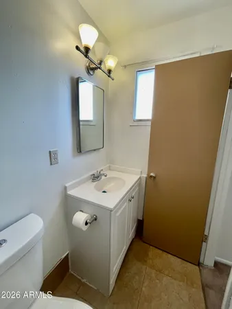 a bathroom with a sink a toilet and mirror