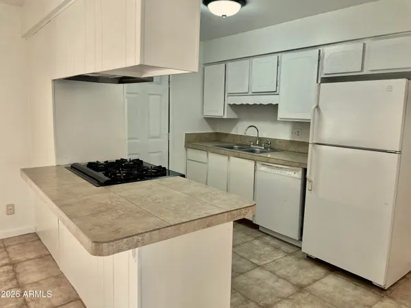 a kitchen with a stove a refrigerator and a sink