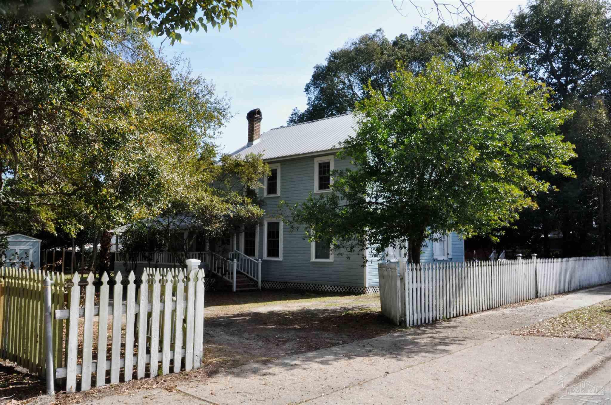 a front view of a house with a tree