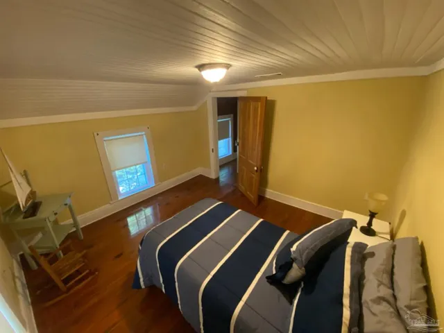 a bedroom with a bed and wooden floor