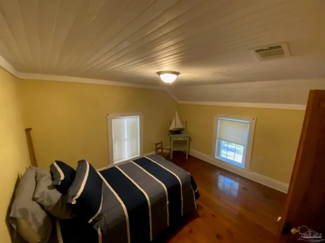 a view of a bedroom with wooden floor and furniture