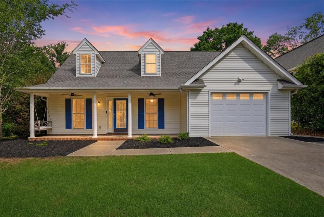 101 Grand Oak Circle Pendleton, SC 29670 - Photo 39 of 40 A welcoming facade with a covered porch and dormer windows, nestled under a dramatic twilight sky.