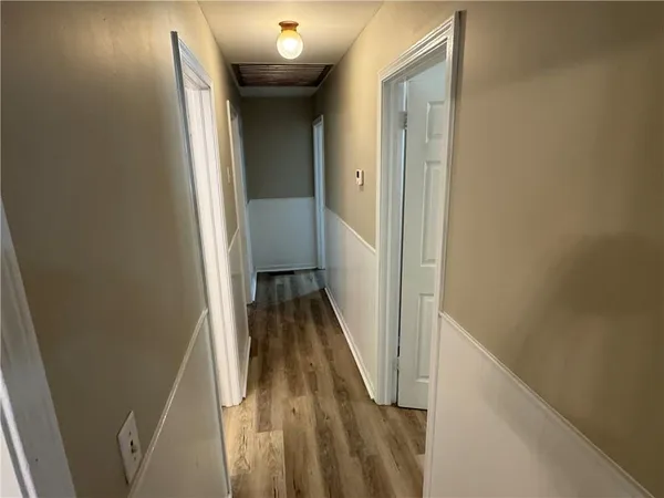 a view of a hallway with wooden floor and staircase