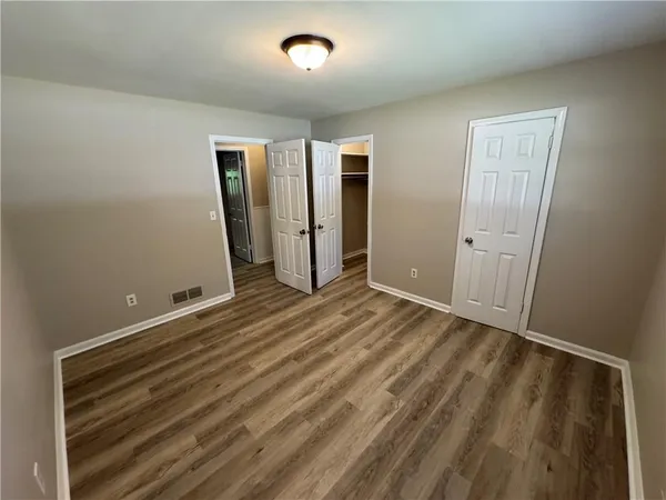 an empty room with wooden floor and closet