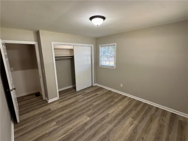an empty room with wooden floor and mirror